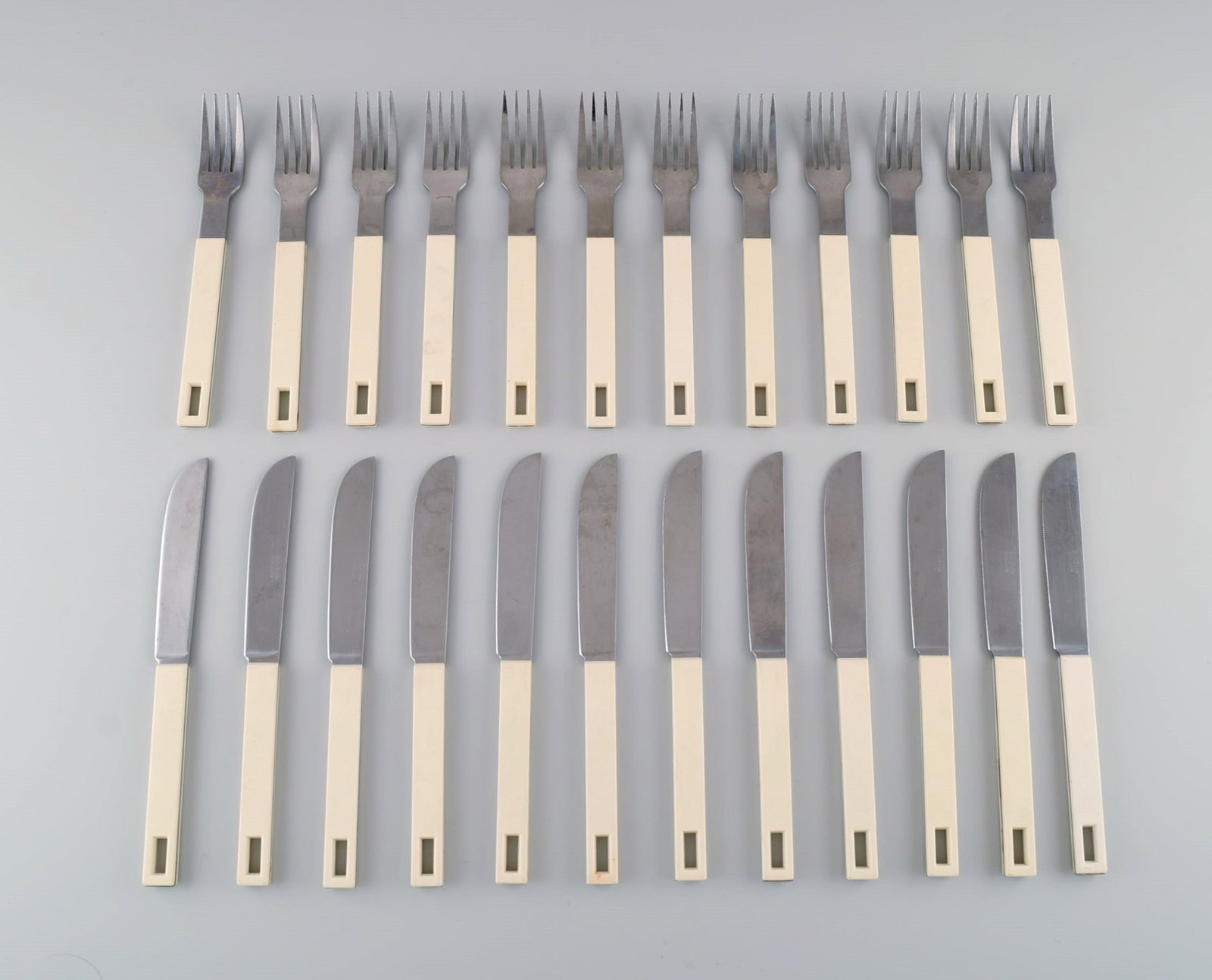 Signe Persson-Melin for Boda. Dinner cutlery for 12 people in cream-colored plastic and stainless: Title: Signe Persson-Melin for Boda. Dinner cutlery for 12 people in cream-colored plastic and stainless steel. Boda Buffe. Sweden, 1960s. Description: Signe Persson-Melin for Boda. Dinner cutlery for