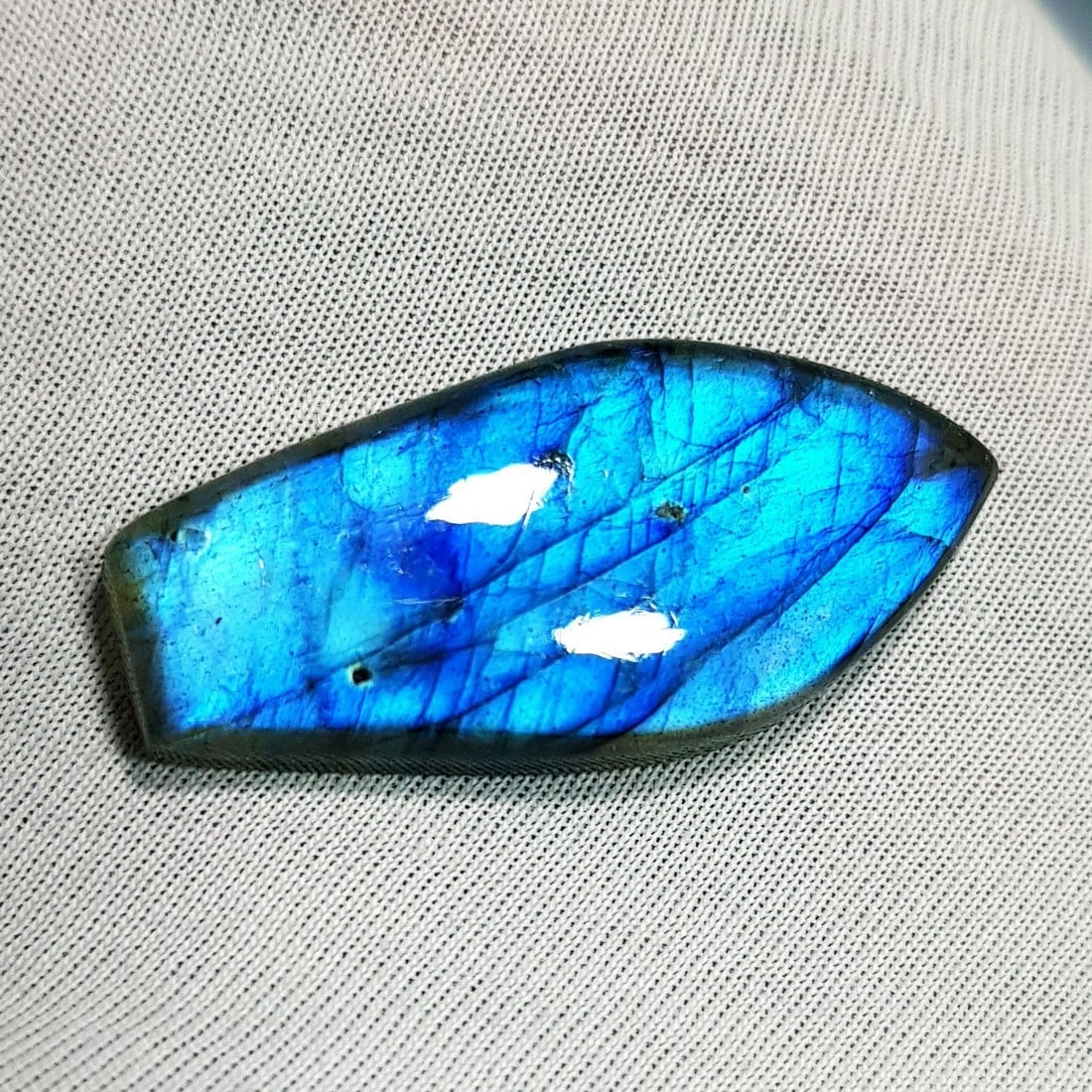 28.48 Ctz Natural Blue Labradorite: No Reserve! Title: 28.48 Ctz Natural Blue Labradorite Color/Clarity: Bluish / Semi Transparent Gemstone: Labradorite Carat Weights: 28.48 Size: 35.85 x 16.75 x 5.80 Additional Information: Fancy Caboc