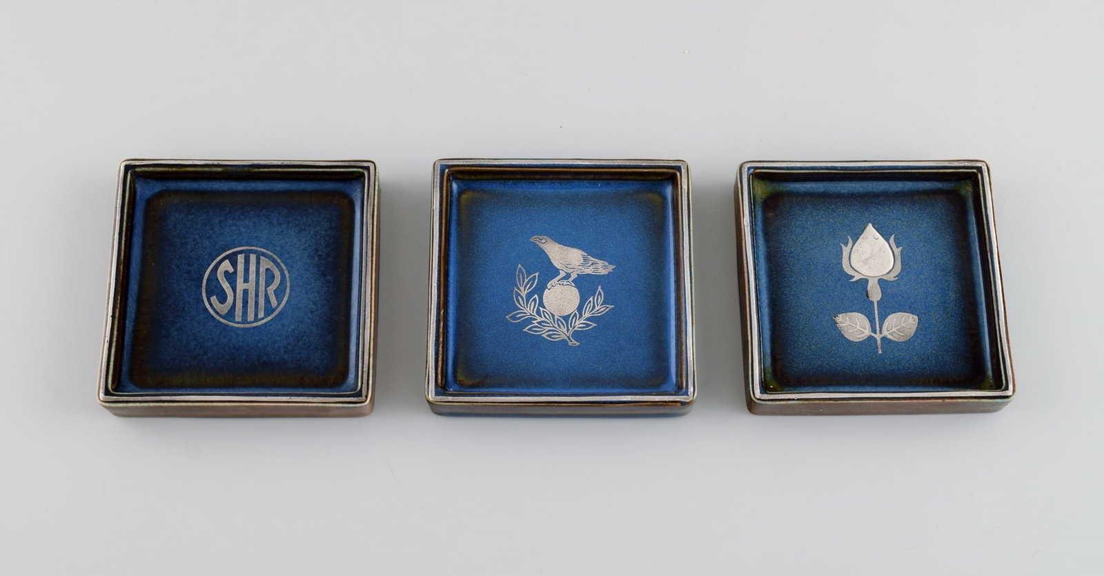 Sven Jonson (1919-1989) Gustavsberg. Three small Lagun dishes in glazed stoneware with silver inlay.: Sven Jonson (1919-1989) Gustavsberg. Three small Lagun dishes in glazed stoneware with silver inlay. Beautiful glaze in shades of blue. 1970s. Measures: 9 x 9 x 1.5 cm. In excellent condition. Stamped
