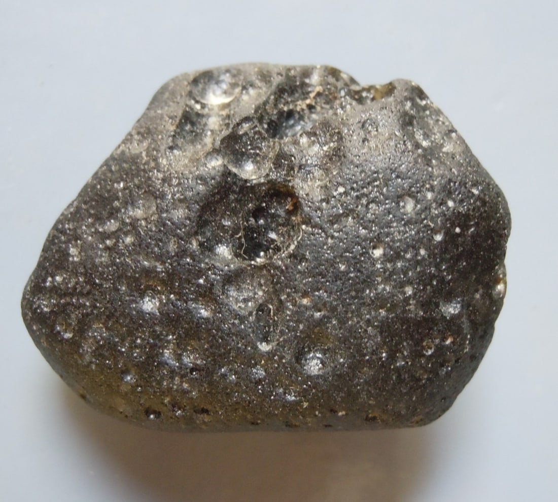 Philippinite Tektite - From Meteorite Impact: Title: Philippinite Tektite - From Meteorite Impact Origin: Paracale, Camarines Norte, Luzon, Phlippines Size: 3x2x1.5 cm / 15 gram Description: irregular rounded philippinite tektite with some deep p