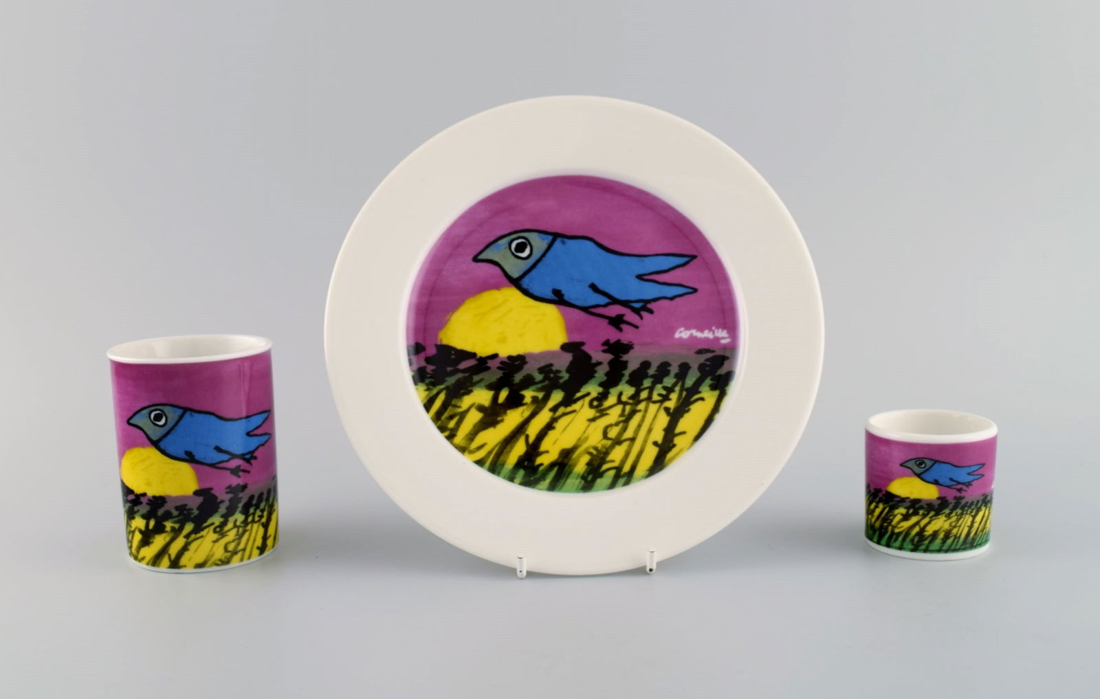 Corneille (guillaume Cornelis Van Beverloo), Dutch Cobra Artist (1922-2010). Coffee Cup, Plate An...: Corneille (Guillaume Cornelis van Beverloo), Dutch CoBrA artist (1922-2010). Coffee cup, plate and egg cup in porcelain decorated with birds over field with sunrise. 1980s / 90s. The cup measures: 9 x