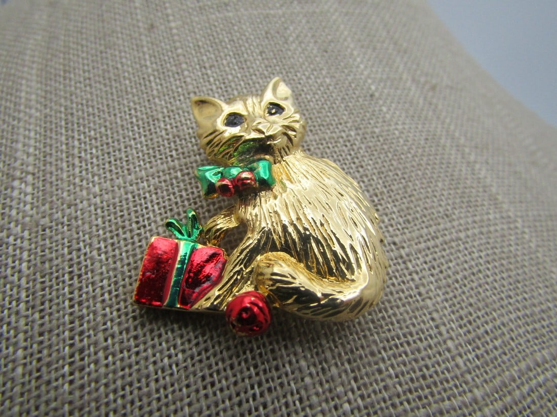 Vintage Enameled Christmas Cat & Bift Brooch, 1960's-1970's.: Vintage Enameled Christmas Cat & Bift Brooch, 1960's-1970's. It is appx. 1.5" tall and 1.25" wide with green and red enameled gift, bow and ornament and black enameled eyes. It is not signed or marked
