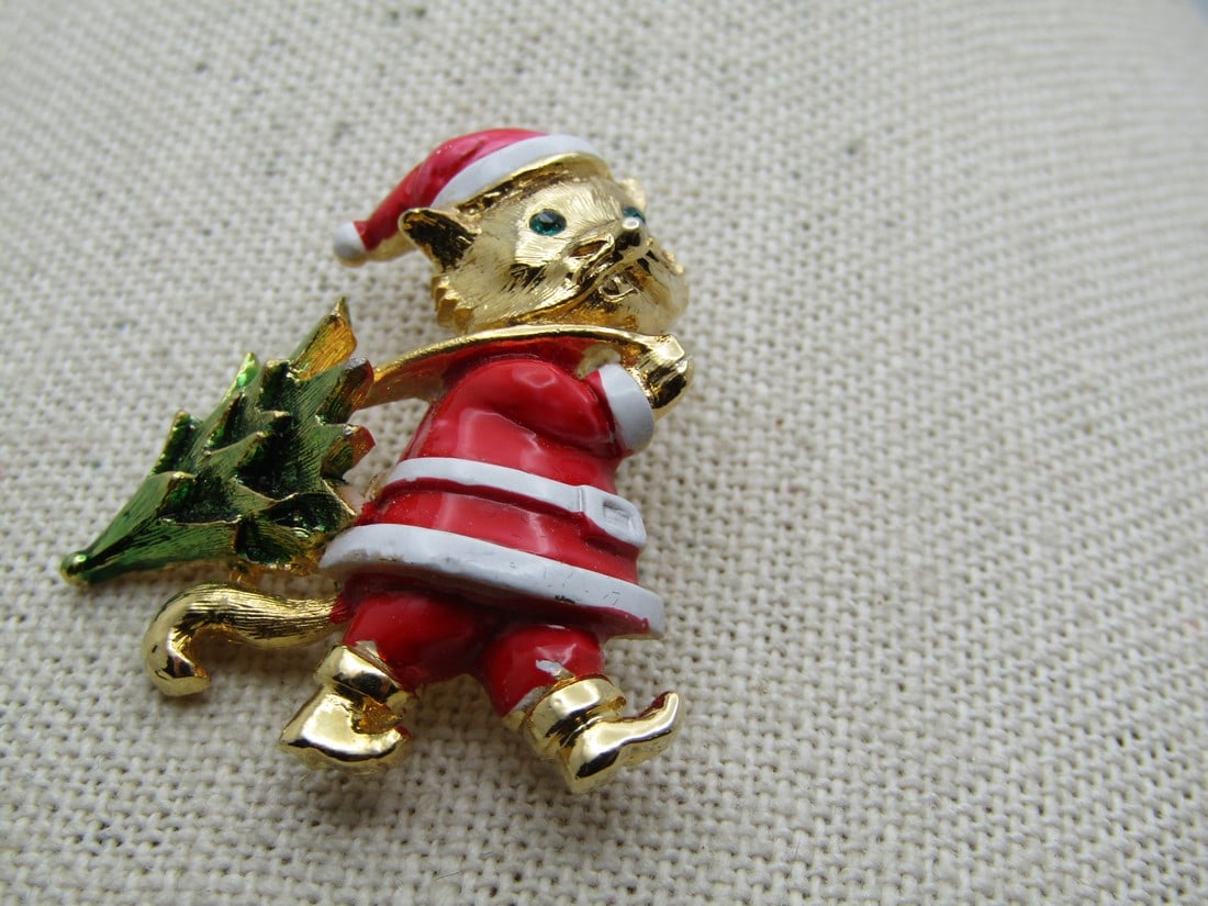 Vintage Santa Kitty With Christmas Tree Brooch, 1960's-1970's: Vintage Santa Kitty With Christmas Tree Brooch, 1960's-1970's. The kitty has green rhinestone eyes and wearing a n enameled Santa Suit with a lightly foil washed green tree. The brooch has a locking c