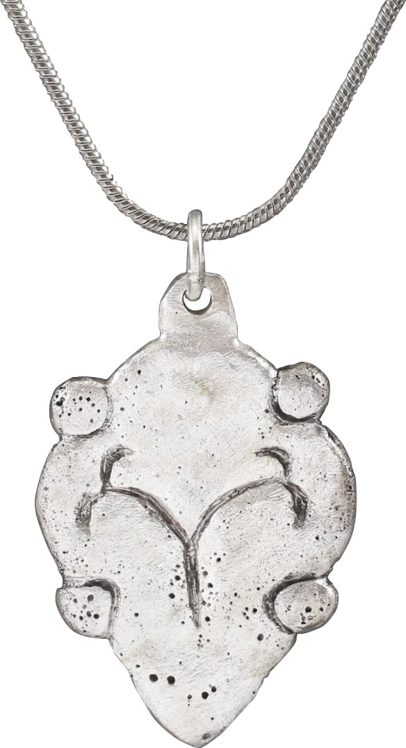 VIKING HEART PENDANT NECKLACE C.950-1050 AD.: Silvered bronze, just over 1” height. The Viking heart in its natural form with rounded top and pointed bottom. Nubs at the quarter points and the field with a scribed trefoil which was a favori