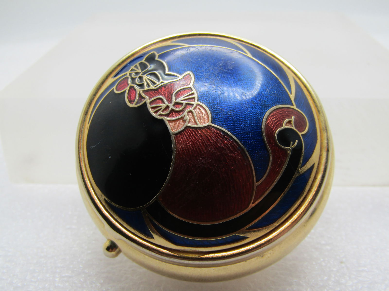 Vintage Enameled Cats Pill Box, 1980's: Vintage enameled cats pill box, 1980's. Enameled in black, blue, peach, and a reddish color. Round with a domed top. Push button to open. It is appx. 2". Gold tone. Two cute cuddling cats on top with
