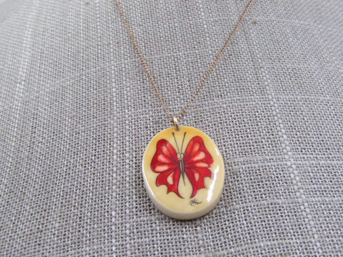 12kt G.F. Painted Butterfly Necklace 15", Signed: 12kt G.F. Painted Butterfly Necklace 15", Signed with what looks like a C and and M that also has a 4 as part of it and two dots - unknown but very well done in reds and pinks with black outlines. Age
