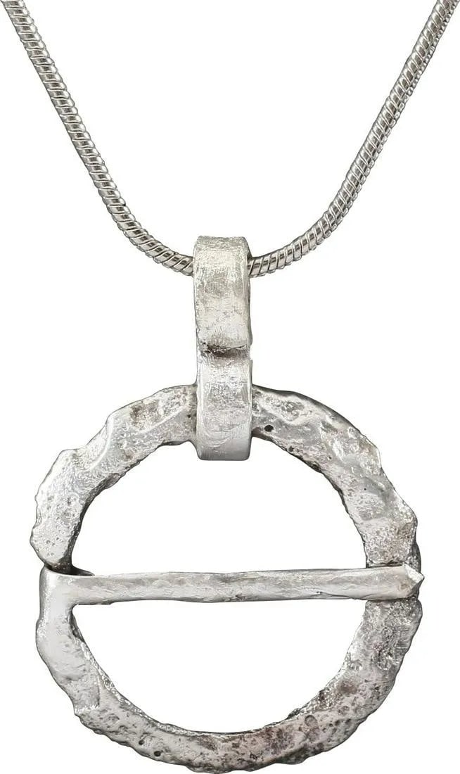 VIKING PROTECTIVE BROOCH PENDANT, 10TH-11th CENTURY: Cambridgeshire, England. Circular bronze, under 7/8" diameter with rounded face and flat back forming a ridged edge and straight cross pin. Surface textured from burial. Worn in numbers on the surface