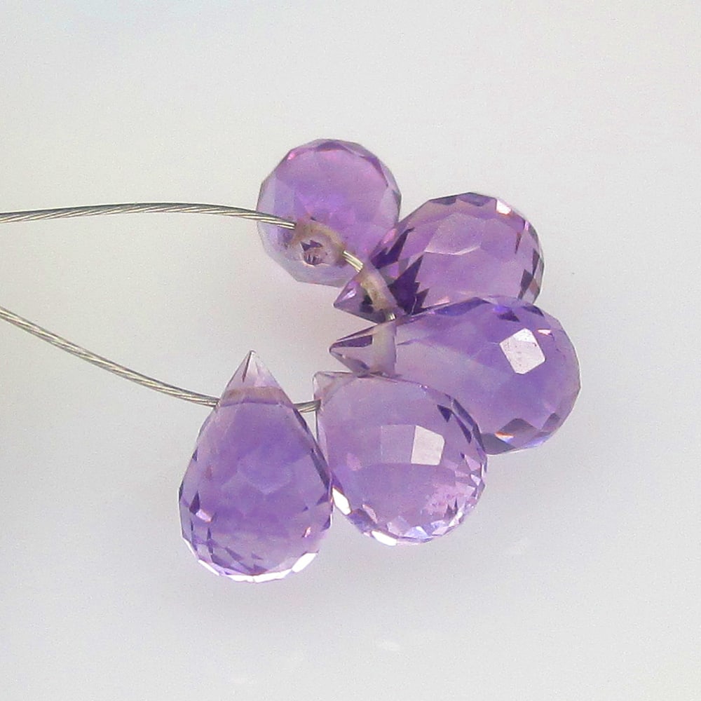 4.76 Ctw Natural 5 Drilled Purple Amethyst Pear Drop Beads: No Reserve! Title: 4.76 Ctw Natural 5 Drilled Purple Amethyst Pear Drop Beads Stone clarity: Transparent Gemstone:Natural Amethyst Beads Carat weights: 4.76 Size/Dimensions: 7.3x4.4 - 8.0x4.5 mm / 5 P