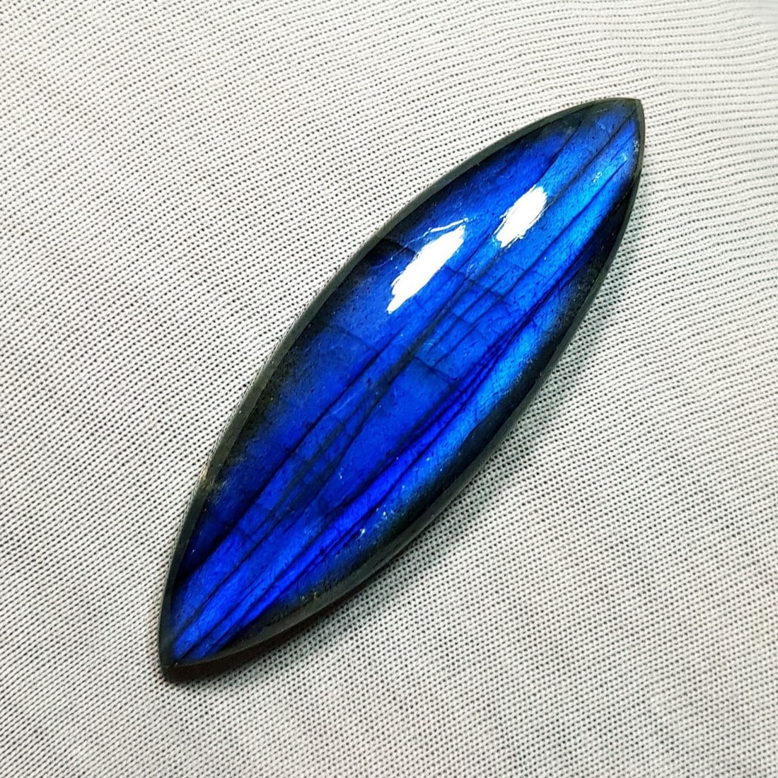 52.38 Ctz Natural Blue Labradorite: No Reserve! Title: 52.38 Ctz Natural Blue Labradorite Color/Clarity: Bluish / Semi Transparent Gemstone: Labradorite Carat Weights: 52.38 Size: 52.90 x 16.90 x 7.40 Additional Information: Maquise Cab