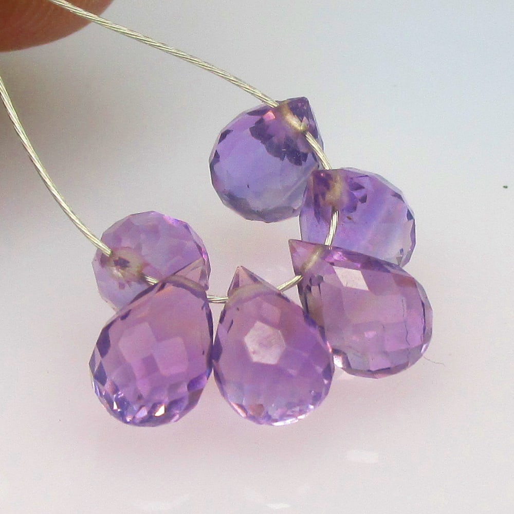 5.06 Ctw Natural 6 Drilled Purple Amethyst Pear Drop Beads: No Reserve! Title: 5.06 Ctw Natural 6 Drilled Purple Amethyst Pear Drop Beads Stone Clarity: Transparent Gemstone:Natural Amethyst Beads Carat Weights: 5.06 Size/Dimensions: 6.8x4.5 - 7.5x4.9 mm / 6 P