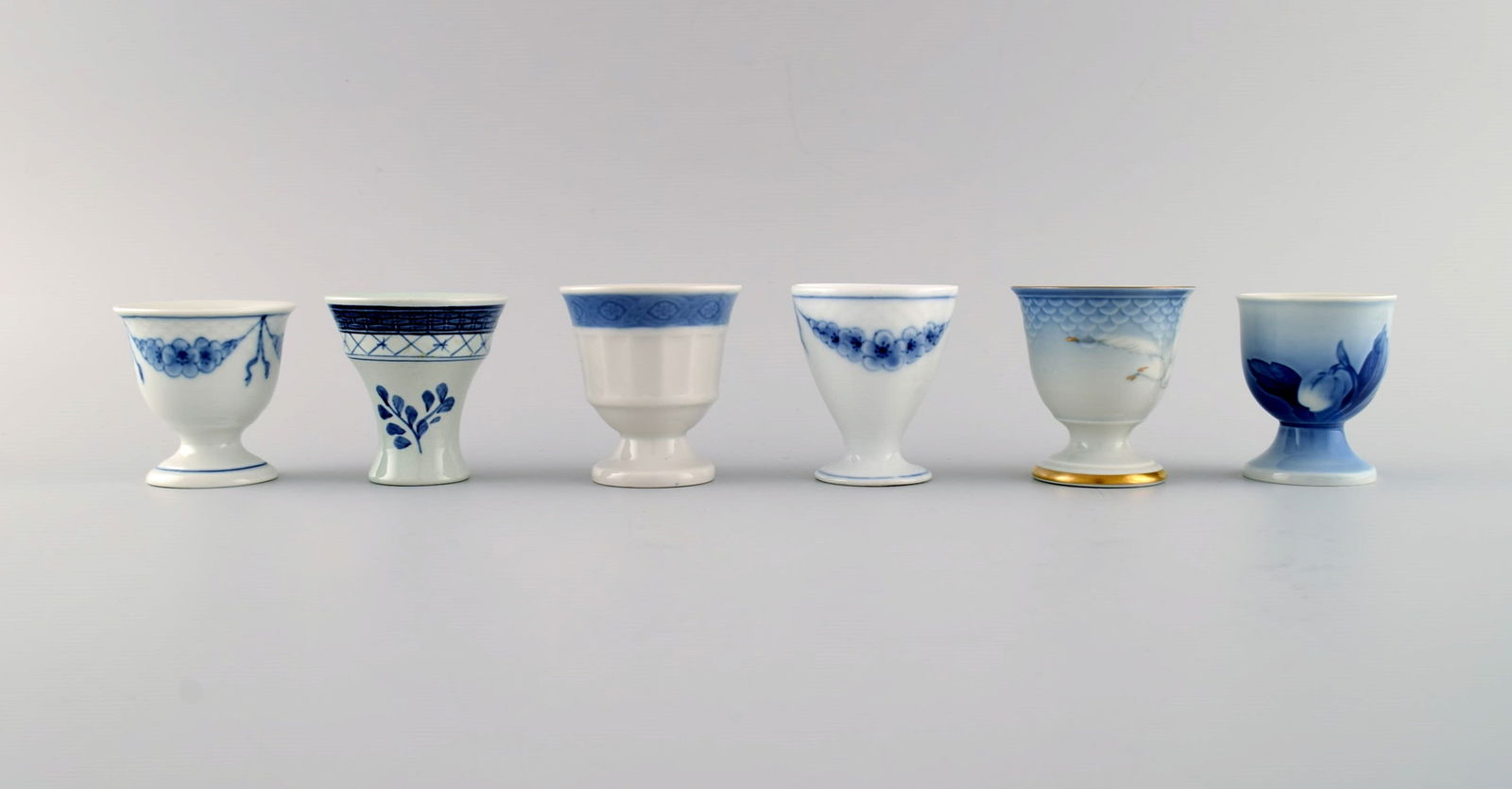 Royal Copenhagen, Bing & Grøndahl and Aluminia. Six egg cups in hand-painted porcelain. 1920s /: Royal Copenhagen, Bing & Grøndahl and Aluminia. Six egg cups in hand-painted porcelain. 1920s / 30s. Largest measures: 6.5 x 5.7 cm. In excellent condition. Stamped. 1st factory quality. Reserve: