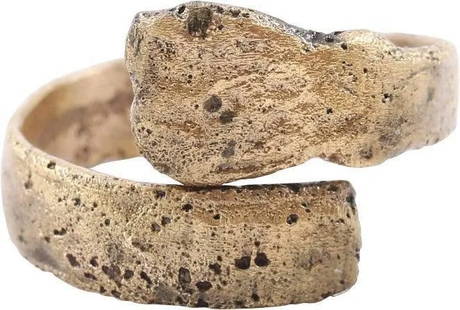 ANCIENT VIKING COIL RING, C.850-1050 AD, SIZE 8 3/4: Gold over bronze. One and a quarter turns, size 8 3/4. Circular section with a stylized animal head terminal at one end. Made by the lost wax process, coil beads, rings, and other adornment elements w