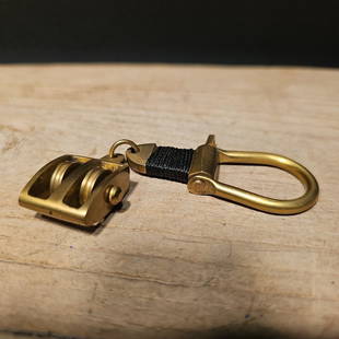 Brass Pulley Key chain: The 4" reproduction brass ship pulley keychain is a beautifully crafted miniature replica of a traditional ship pulley, designed to serve as a functional and decorative keychain. It is meticulously