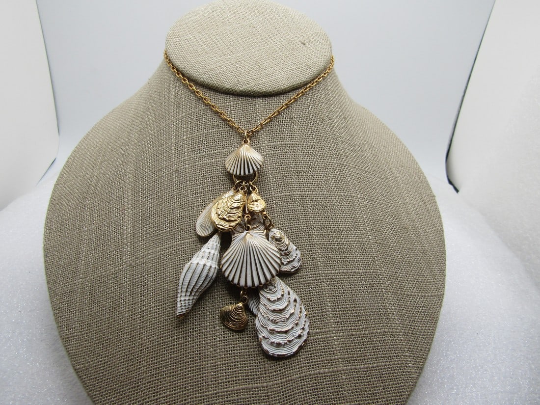 Vintage Dangling Seashell Necklace, White Enamel Washed, 18", 1960's-1970's: Vintage dangling seashell necklace, white enamel washed, 18", 1960's-1970's. The chain is an oval link with spring clasp. The chain is appx. 2mm wide. It has a mix of gold tone shells and gold tone sh