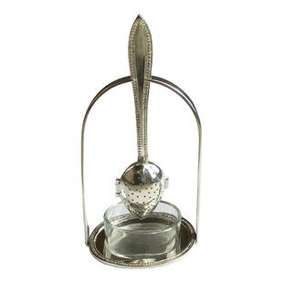 7" Silver-Plated Loose Tea Strainer Spoon and Holder w Glass Drip Cup: Title: 7" Silver-Plated Loose Tea Strainer Spoon and Holder w Glass Drip CupDescription: 7" tall with spoon in place, 3-1/2" wide Meet our beautiful reproduction silver-plated tea strainer! It adds