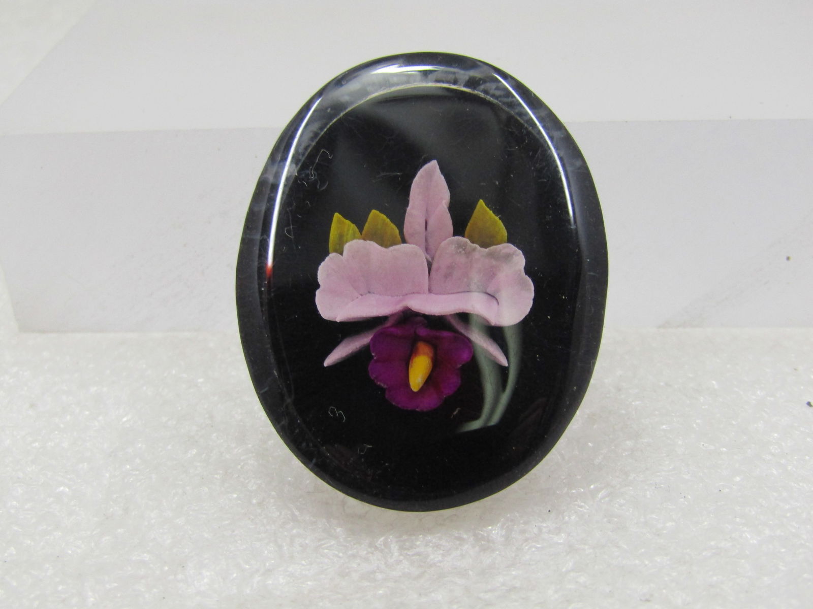 Vintage Reversed Carved & Painted Orchid Brooch, 1940's-1950's: Vintage Reversed Carved & Painted Orchid Brooch, 1940's-1950's. Black background with clear top that the pink and purple orchid can be easily seen through. It is wider on top at 1-5/8" tall and 1.25"