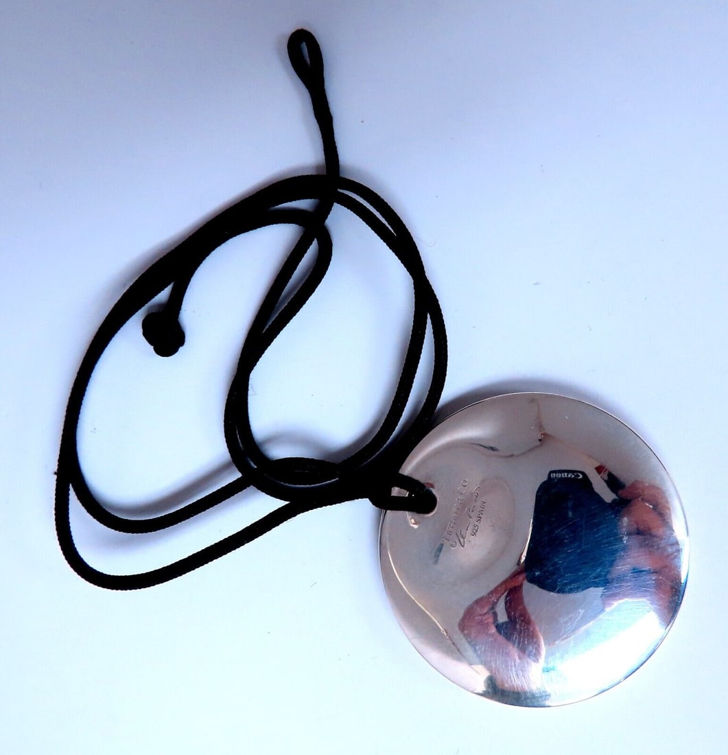 Authentic Tiffany Elsa Perretti 35mm Sterling Silver Disc Pendant: Authentic Tiffany Elsa Perretti Sterling Silver Disc 35mm 13.7 grams Comes with black cord as shown. Reserve: $396.00 Shipping: Domestic: Free shipping to anywhere within the contiguous U.S. Internati