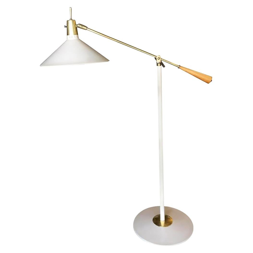 Arredoluce Style Adjustable Midcentury Reading Floor Lamp: Arredoluce style adjustable midcentury reading floor lamp featuring an off-white colored enameled metal shade with brass accents with solid wood grips and a solid brass articulating arm. Made in Italy
