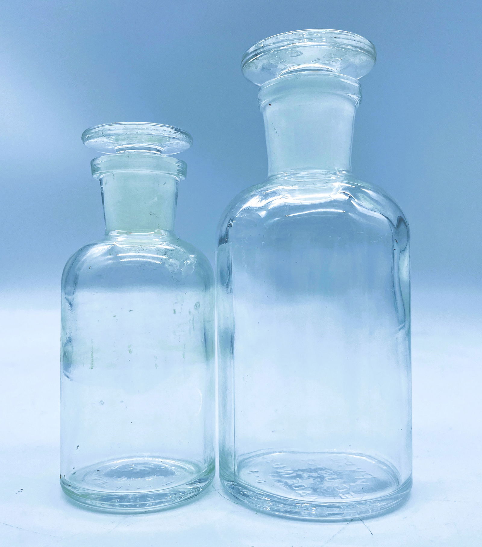 Pair of PYREX APOTHECARY CLEAR GLASS MEDICINE BOTTLE WITH GLASS STOPPER LIDS: Title: Pair of PYREX APOTHECARY CLEAR GLASS MEDICINE BOTTLE WITH GLASS STOPPER LIDS Date/Period: unknown Dimension: 5" & 4" tall Material: glass Additional Information: Pair of PYREX APOTHECARY CLEAR