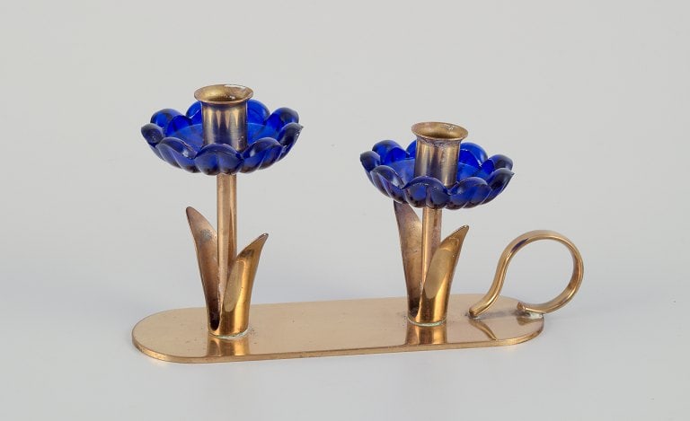 Gunnar Ander for Ystad Metall, Sweden. Candlestick holder in brass and blue art glass shaped like: Gunnar Ander for Ystad Metall, Sweden. Candlestick holder in brass and blue art glass shaped like flowers. For two candles. From the 1950s. In excellent condition with good patina. Dimensions: W 13.5