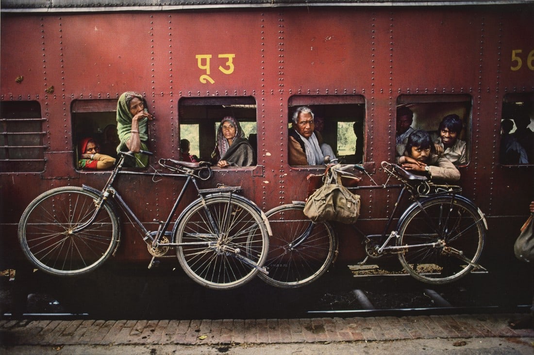 STEVE MCCURRY - Bicycles on the Side of a Train, 1983: Artist: Steve McCurry Title: Bicycles on the Side of a Train, West Bengal, India, 1983 Medium: Photo Litho, 2012, Italy Dimensions: 14x9.35" Description: Heat Wax Mounted on 12x16" Conservation Board
