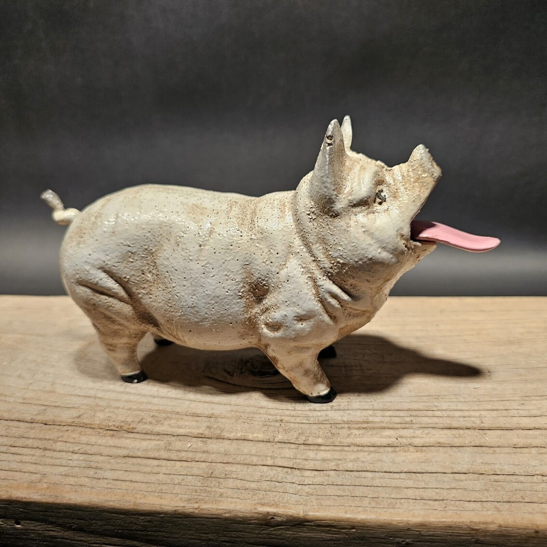 7 1/2" Cast Iron Pig Mechanical Coin Bank: 7 1/2" Long x 5" Tall 3" Wide Great unique reproduction folk art cast iron pig coin bank. This piece was made to look just like an antique, but is actually new. Pressing down on the tail pulls the ton