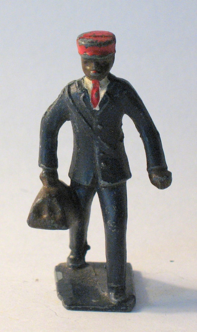 Vintage cast metal train porter toy figure.: Title: Vintage cast metal train porter toy figure. Date/Period: 1930's Dimension: 2 1/4” high Additional Information: Nice vintage cast metal toy figure of a black train porter in original paint