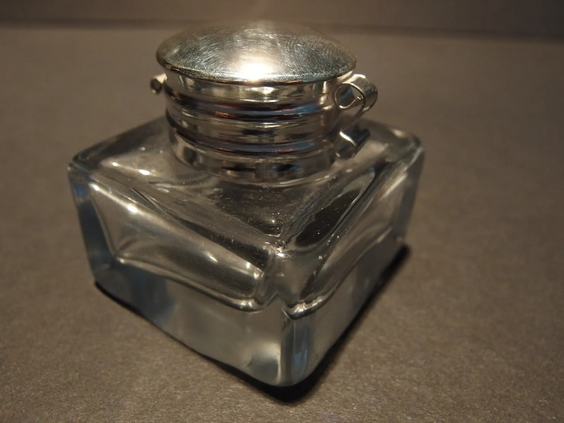 Clear Square Thick Glass Inkwell Ink pot Bottle: Charming 1 3/4" High x 1 3/4" wide Reproduction antique clear glass inkwell. Very heavy thick clear glass each with charming subtle signs of being hand made. The hinged shiny lid is nickel plated bras