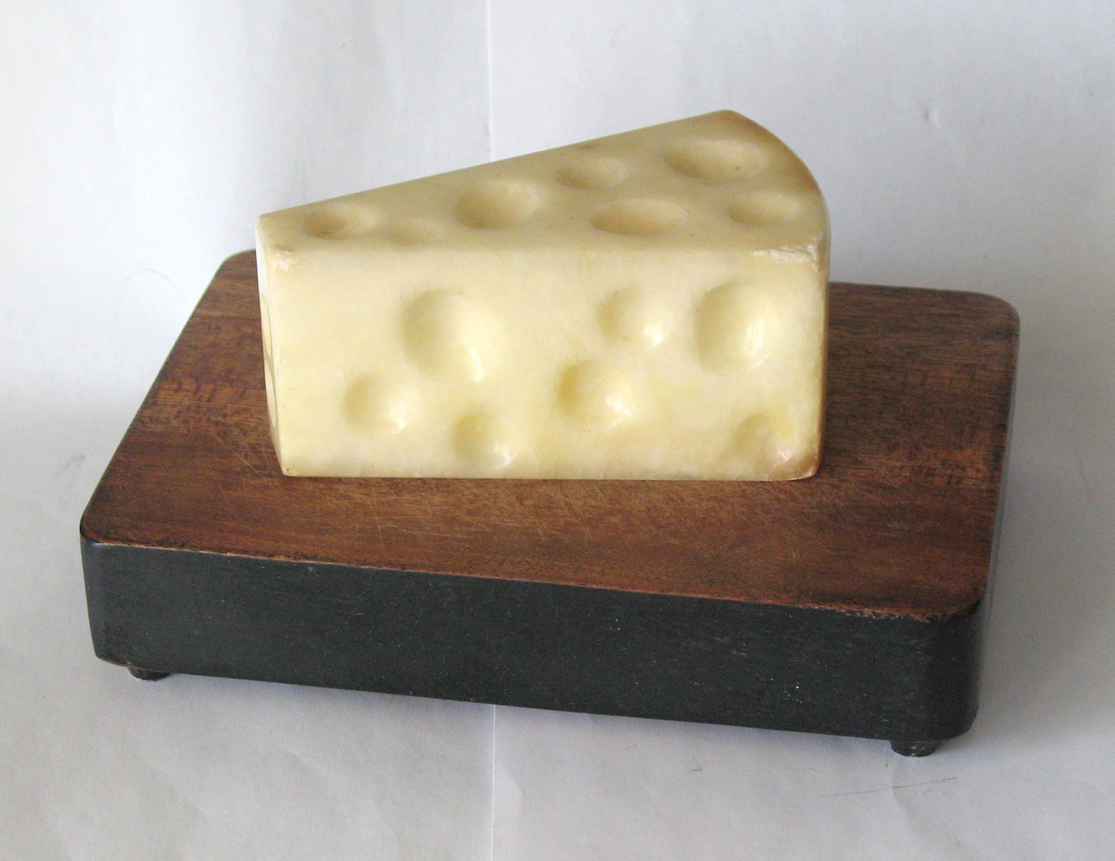 Antique wedge of stone Swiss cheese.: Title: Antique wedge of stone Swiss cheese. Date/Period: 1940's Dimension: 4 1/2” x 2 1/2” x 2” Additional Information: Nice antique wedge of stone Swiss cheese in very good patina &