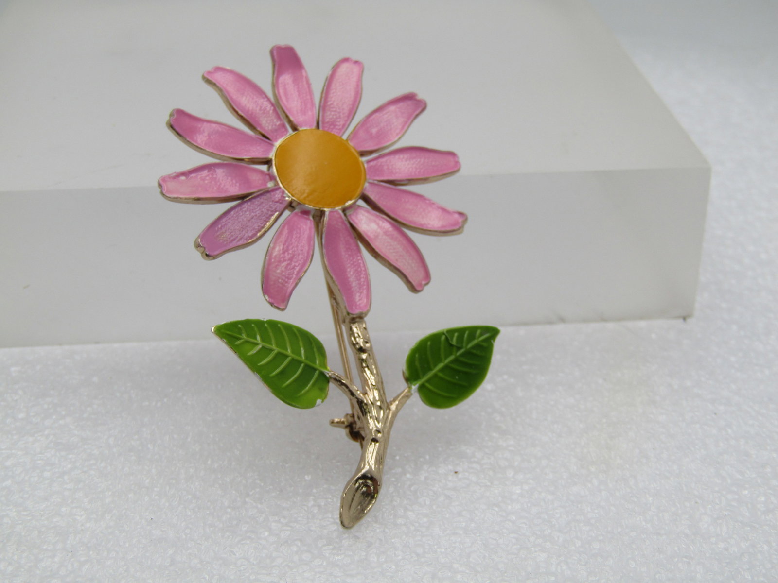 Vintage Enameled Pink Daisy Brooch, 1960's-1970's, 2.5": Vintage Enameled Pink Daisy Brooch, 1960's-1970's, 2.5". Pink petals on the daisy with a white under-shading and green leaves. Gold tone stem. The pin is appx. 2.5" tall and 1.5" wide. It is not signe