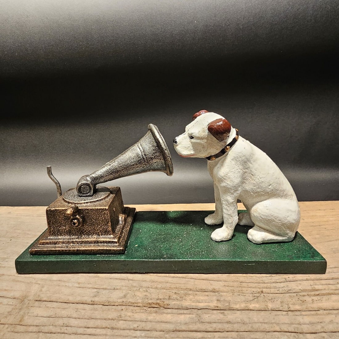Cast Iron Nipper Dog Figurine on Green Base, Rogers Foundry, Birmingham: 8 3/4" Long x 4 1/2" Tall x 3 1/4" Wide This reproduction cast iron ornament is from the famous British record label, HVM ("His Master's Voice"). It shows Dog Nipper with a gramophone and is hand-pain