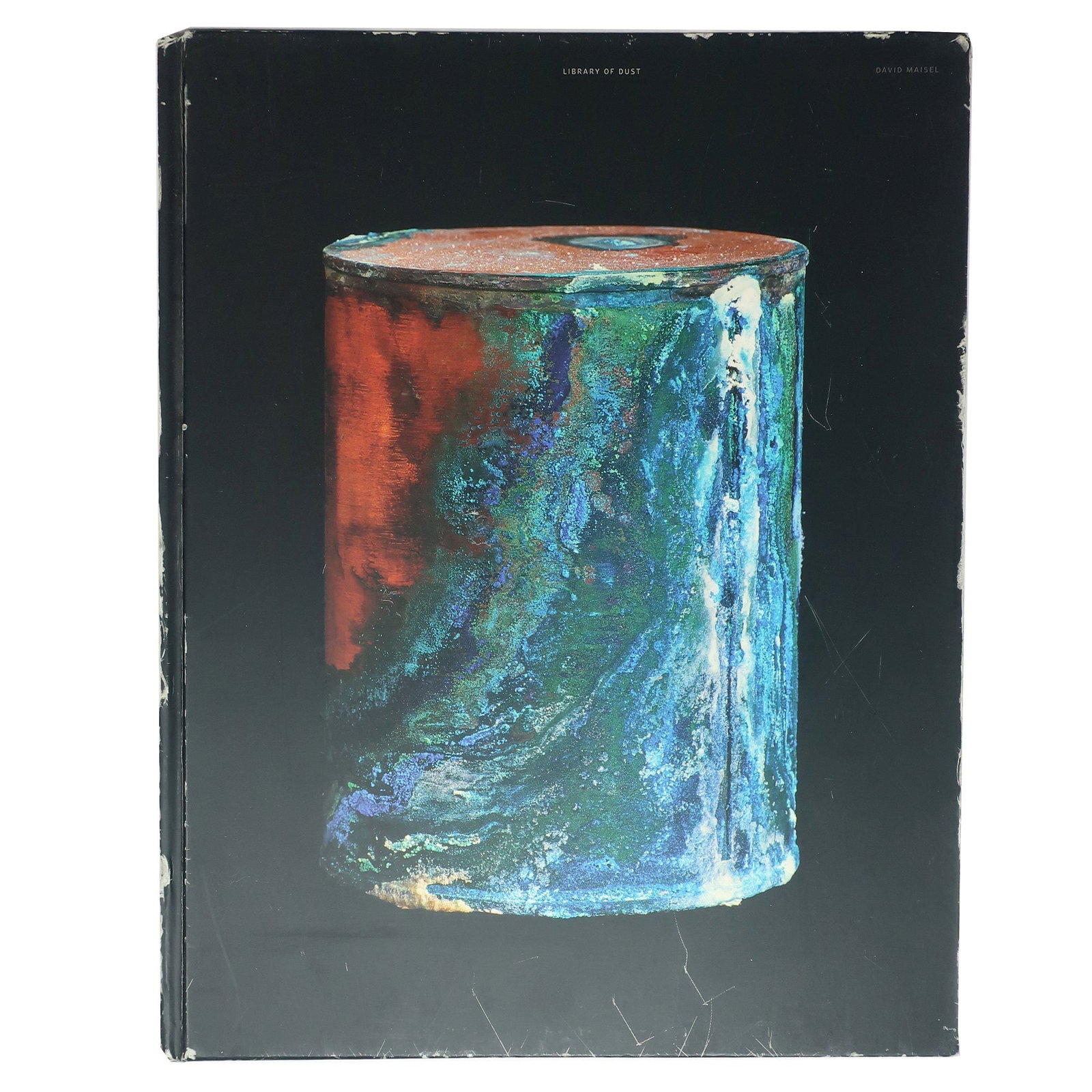 Signed Library of Dust book by David Maisel: Renowned photographer David Maisel has created a somber and beautiful series of images depicting canisters containing the cremated remains of the unclaimed dead from an Oregon psychiatric hospital. Da