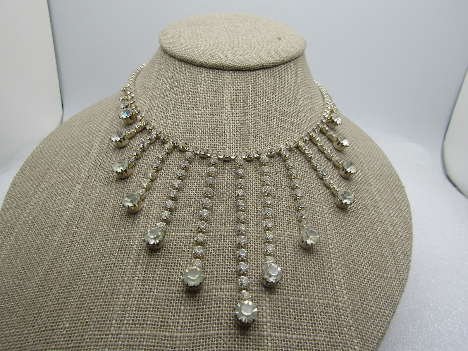 Vintage Clear Rhinestone Staggered Drop Necklace, 16", Hook Clasp: Vintage Clear Rhinestone Staggered Drop Necklace, 16", Hook Clasp. Silver tone settings in square and round shapes. Most of the 16" is appx. 3.3mm wide square settyins for 3mm clear round stones. Ther