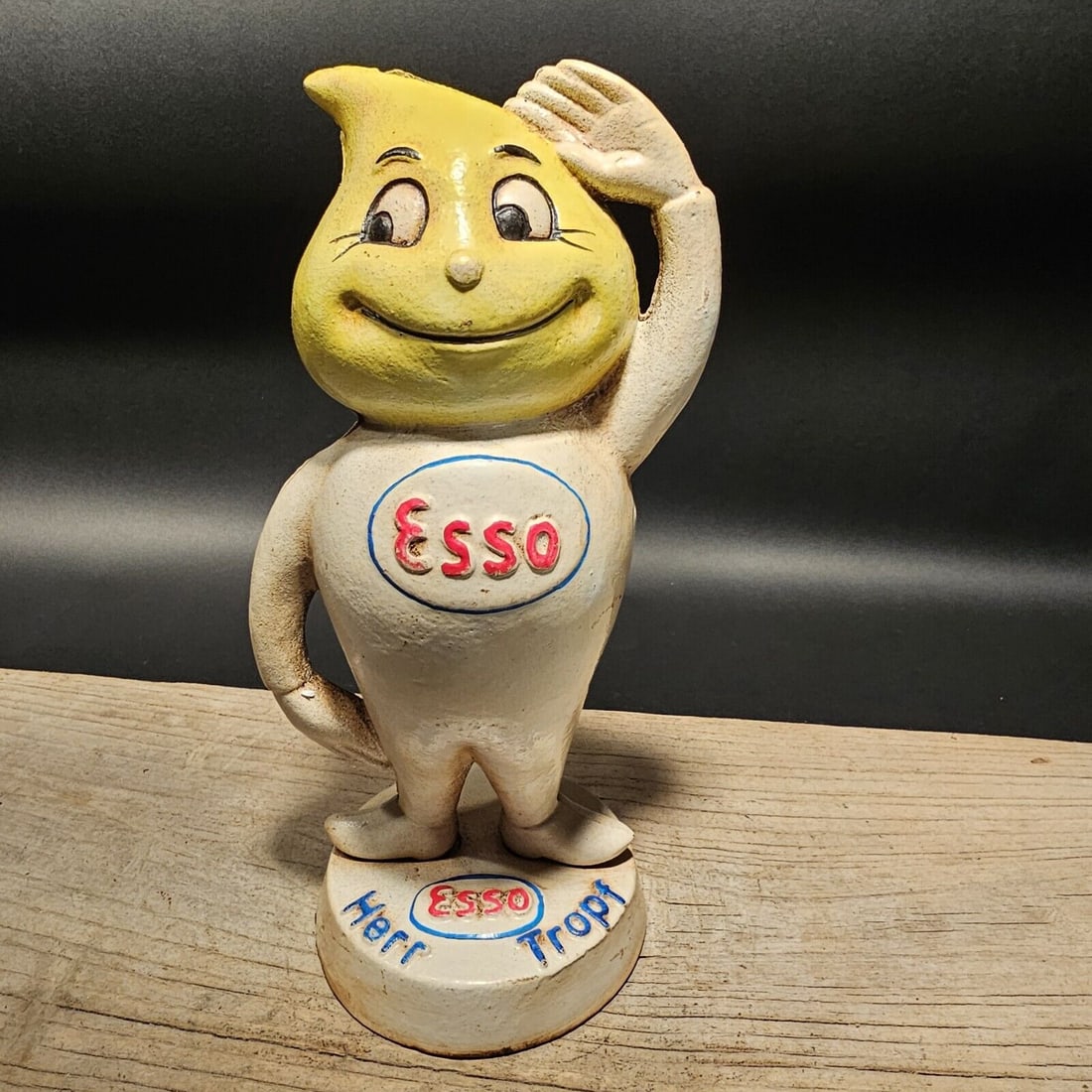Cast Iron Esso Coin Bank: 9" Tall x 4" wide This remarkable reproduction of an antique ESSO coin bank is incredibly authentic, featuring hand-painted details and a decorative screw on the back. It holds a nostalgic charm. Howe