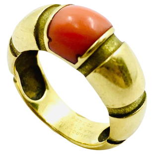 Vintage Mauboussin Gold Coral Ring: A vintage coral ring by Mauboussin made in 18k gold. This architectural ring with the cabochon cut coral designed with six vertical grooves in the band. These grooves are textured, and the band is pol