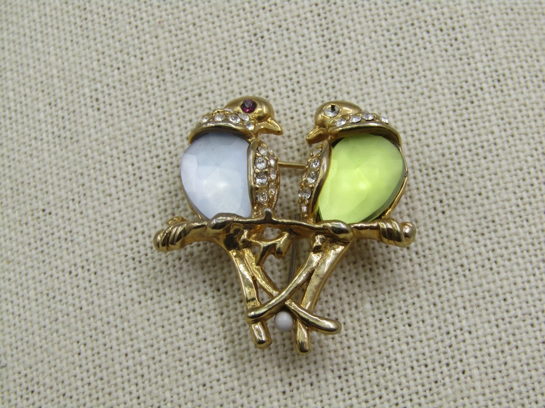 Vintage Love Birds Brooch, Rhinestones, Blue/Yellow-Green, 1.25": Vintage Love Birds Brooch, Rhinestones, Blue/Yellow-Green, 1.25" tall and wide. One bird has a pale bue faceted chest and the other a yellow/green with rhinestone accented wings and eyes. Sitting on a
