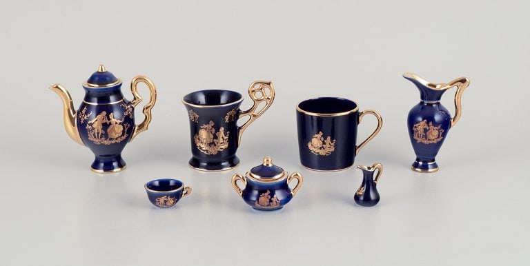 Limoges, France. Seven pieces of miniature porcelain, decorated with 22-karat gold leaf and a: Limoges, France. Seven pieces of miniature porcelain, decorated with 22-karat gold leaf and a beautiful royal blue glaze. Scène galante. Approximately 1970. Provenance: From a large French private co