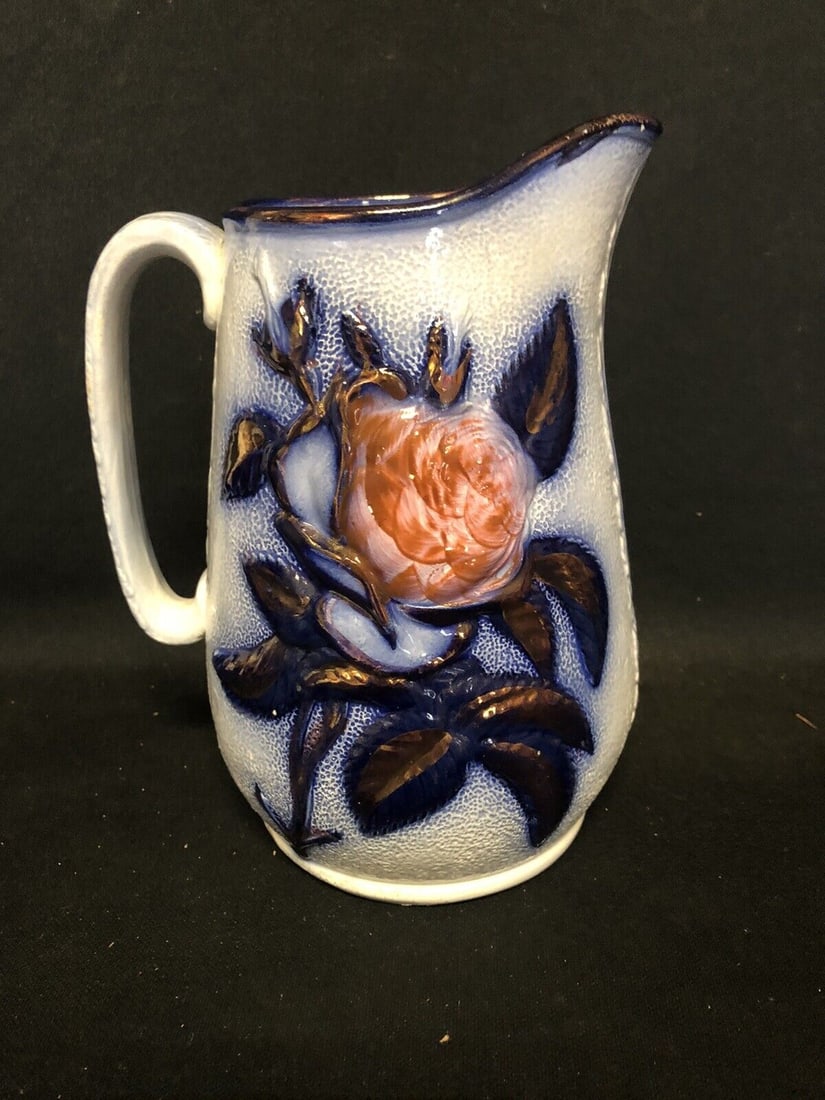 Flow Blue Pitcher: It is 8 1/8” high and dates around the 1860’s. It has roughness on the top rim in several spots and paint wear on one flower. Otherwise it has no other issues. Shipping: Domestic: Flat-rat
