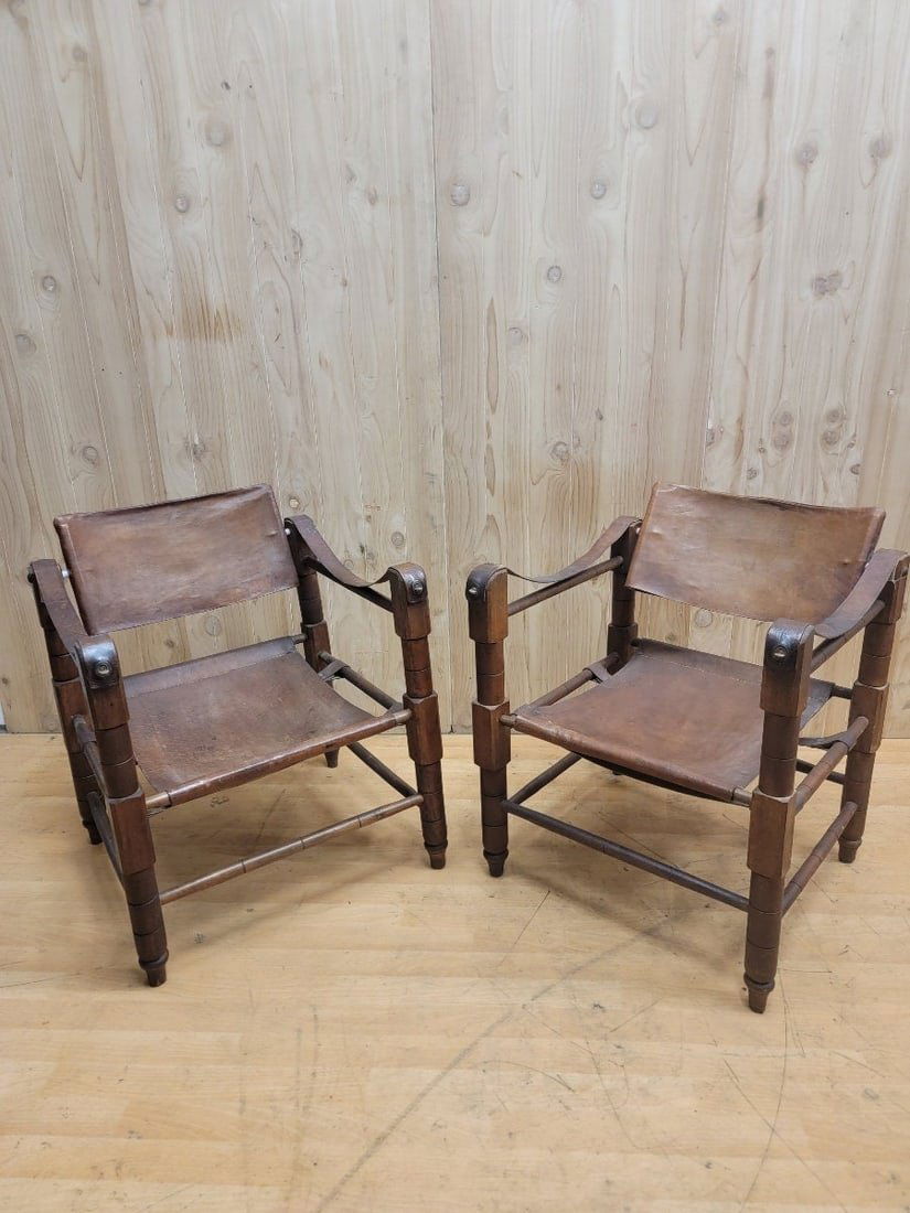 Mid Century Modern Kaare Klint Style Brutalist "Cognac" Leather Safari Chairs - Pair: Vintage from the 1950sMaterials: leather, woodOverall width: 23 inchesOverall height: 29 inchesOverall depth: 21.5 inchesSeat height: 15 inchesSeat depth: 20 inchesMid Century Modern Kaare Klint Style