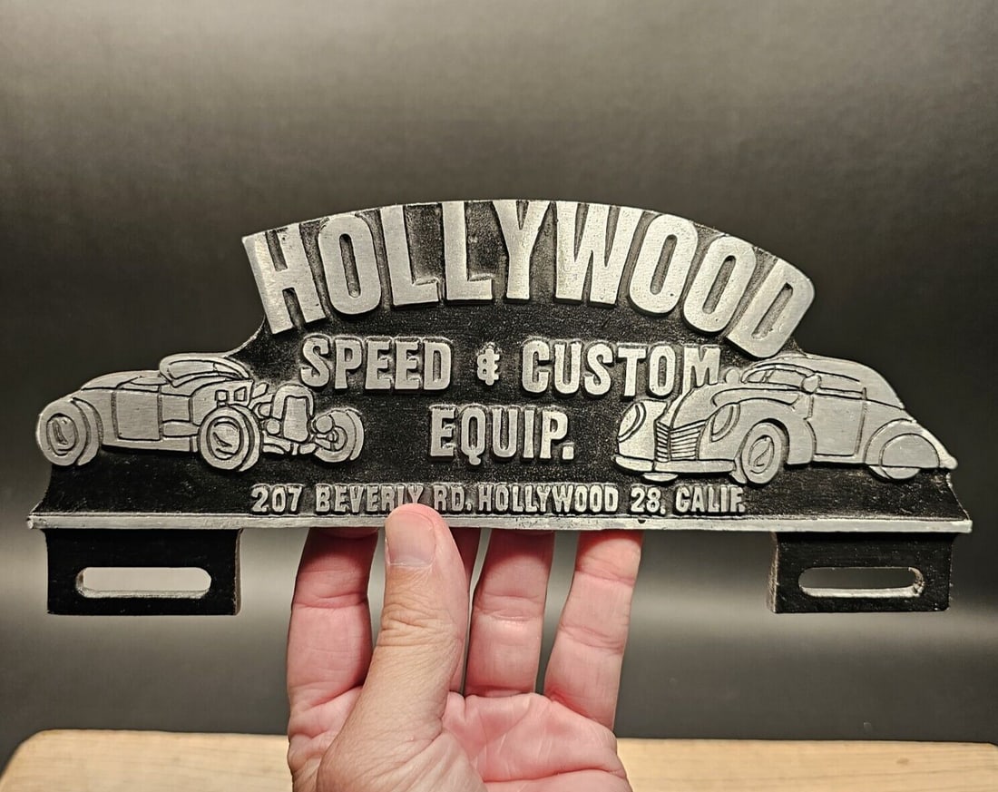 Aluminum Hollywood License Plate Fob Topper: 10 1/2" Wide x 4 1/2" Tall Wonderful reproduction license plate topper. Good detail aluminum, slightly aged to look like an antique. Certainly hard to tell its age. Reserve: $20.00 Shipping: Domestic: