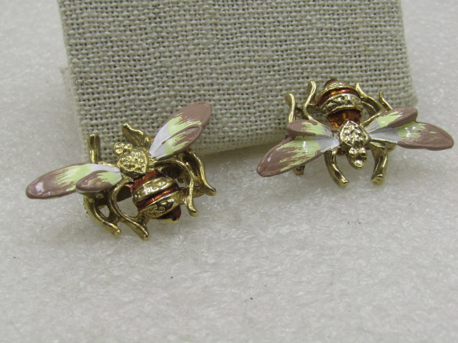 Pair of Enameled Bee Brooches, 1.5" by 1", Gold Tone, 1960's: air of Enameled Bee Brooches, 1.5" by 1", Gold Tone, 1960's. They have textured parts to the torso with an amber enameled sripe to give it the bee striping and he wings are enameled in tan and porcela