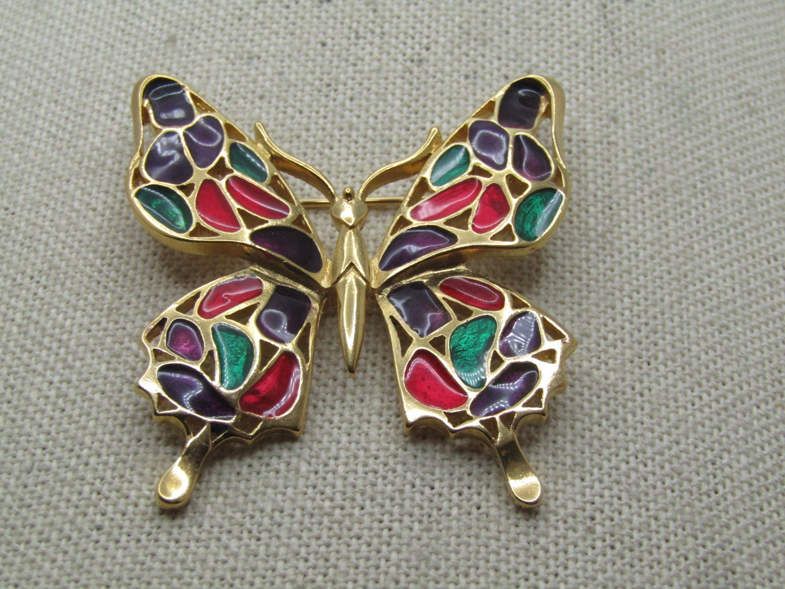 Vintage Enameled Butterfly Brooch, Signed Trifari, 1970's-1980's: Vintage Enameled Butterfly Brooch, Signed Trifari, 1970's-1980's. This has a stained glass design with gold rimmed sections in purple, red, green in a rich enameling that is somewhat translucent Close