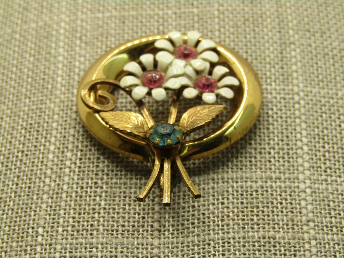 Vintage Enameled Rhinestone Floral Pendant, Gold Tone, 1950's-1960's: Vintage Enameled Rhinestone Floral Pendant, Gold Tone, 1950's-1960's. It is 1.75" long and 1.25 wide. Three white enameled daisy flowers with stems extending beyond the frame and a blue rhinestone bet