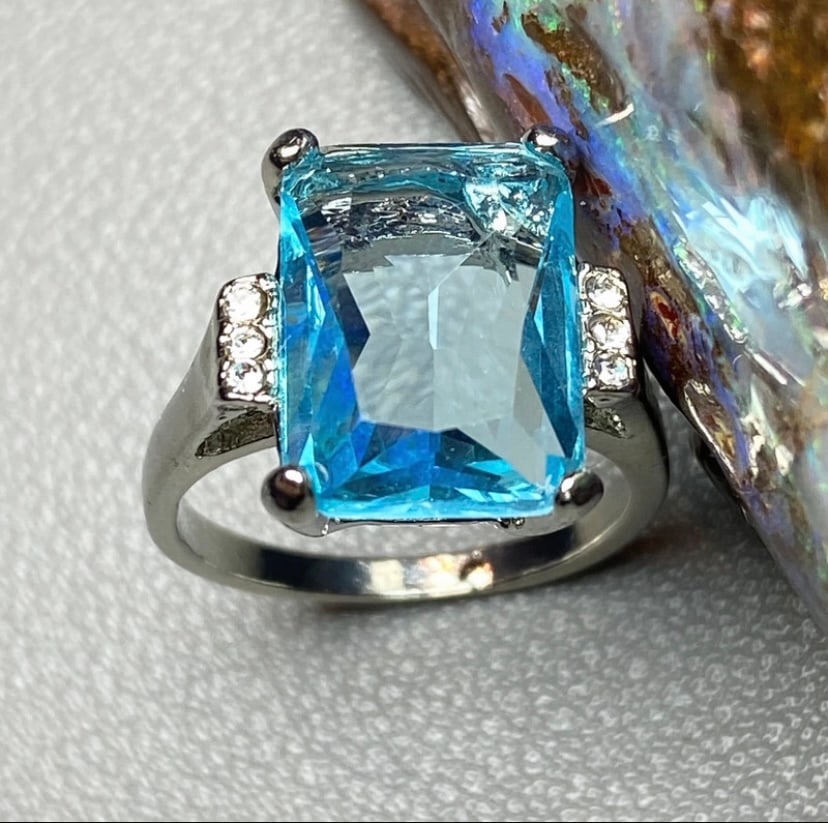 Large rectangle aquamarine crystal titanium stell dressing ring: Title: Large rectangle aquamarine crystal titanium stell dressing ring Description: Very beautiful and sparkling, the photos can not show its shinning. Date/Period:Mordern Dimensions:Ring US size: 7;