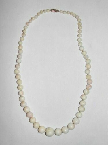 Angel Skin Coral Graduated Bead Necklace: Gorgeous classic angel skin coral necklace. Lovely graduation and recently restrung on white silk, hand knotted to keep these lovely off white with light pink inclusion beads from wearing down. Circa