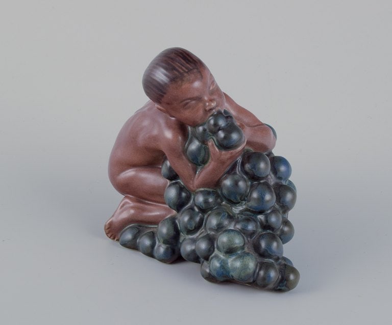Kai Nielsen (1882-1924) for Bing & Grøndahl. Stoneware figurine depicting "Little Bacchus with: Kai Nielsen (1882-1924) for Bing & Grøndahl. Stoneware figurine depicting "Little Bacchus with Grapes". From the Grape Harvest Series 1912. Marked. Perfect condition. First factory quality. Dimen