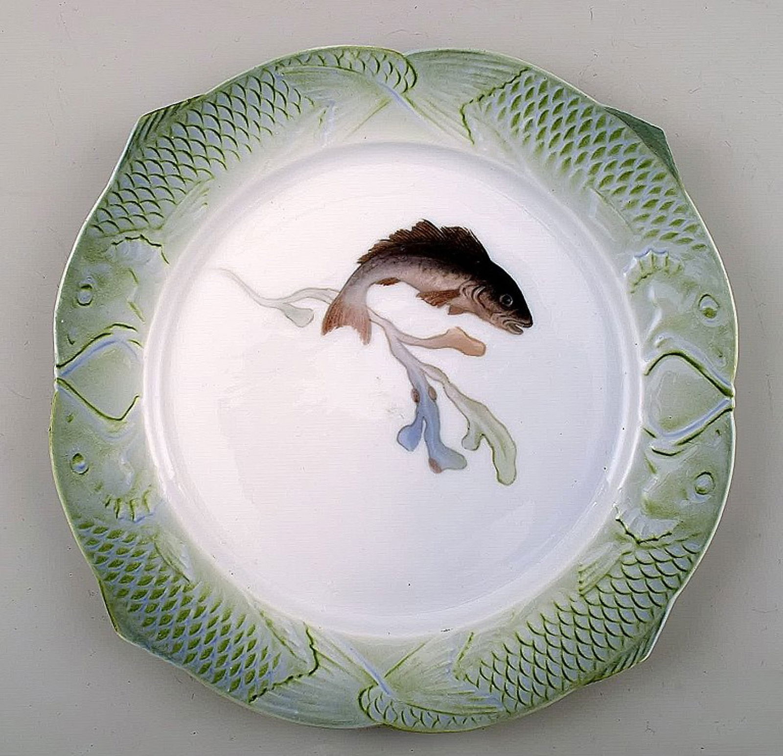 Arnold Krog for Royal Copenhagen: "Fish service" dinner plate in porcelain, decorated in colors with: Arnold Krog for Royal Copenhagen: "Fish service" dinner plate in porcelain, decorated in colors with a fish. Number 1/3002. Measures: 25 cm. 1st. factory quality, in perfect condition. Reserve: $210.0