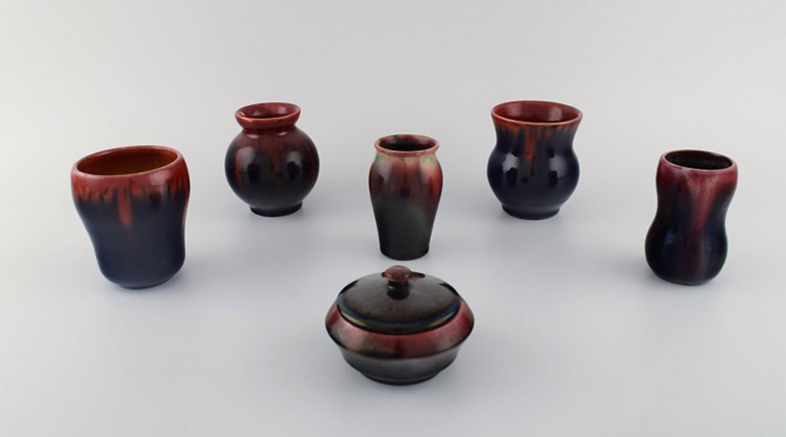 Michael Andersen, Bornholm. Five vases and a lidded jar in glazed ceramics. Beautiful glaze in red: Michael Andersen, Bornholm. Five vases and a lidded jar in glazed ceramics. Beautiful glaze in red and dark shades. 1950's. Largest vase measures: 9 x 8.5 cm. The lidded jar measures: 9.5 x 6 cm. In v