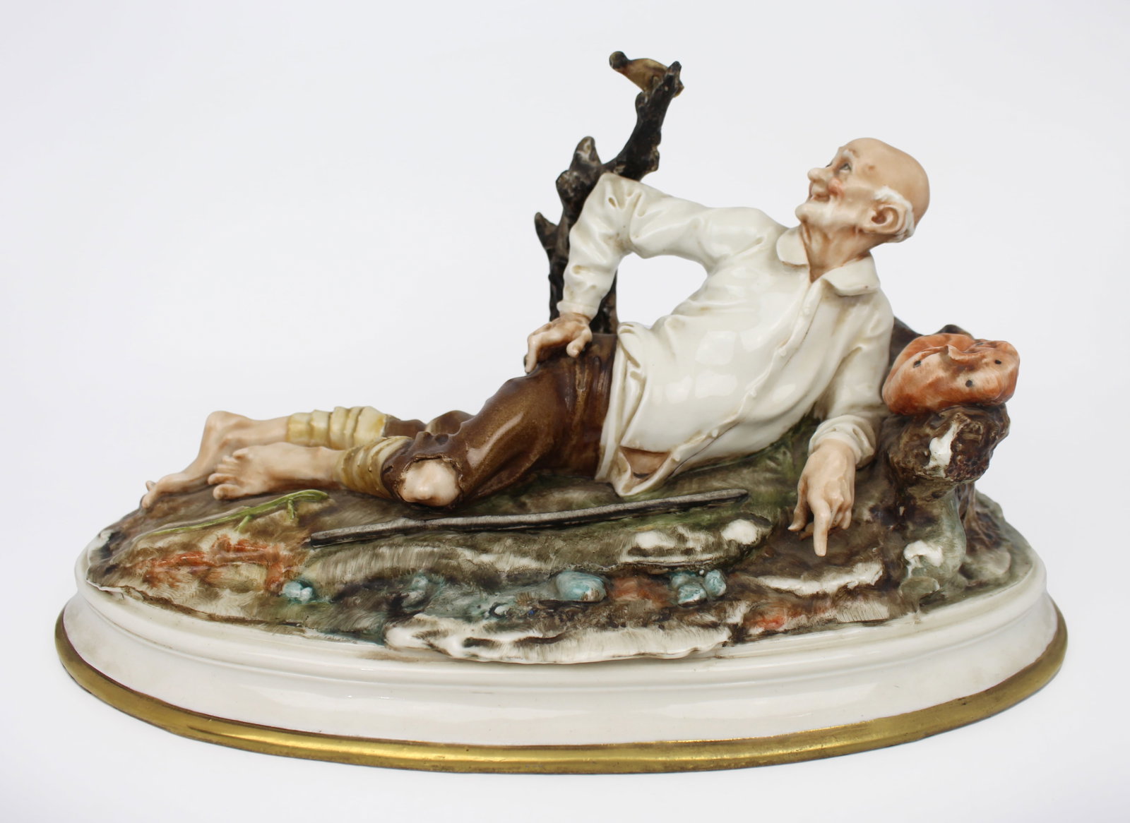 Vintage Capodimonte Sculpture Reclining Old Man & Bird: Vintage Capodimonte Sculpture Reclining Old Man & Bird Vintage 20th century Italian porcelain sculpture by Capodimonte A dishevelled old man lying down looking up at a bird on the branch in wonder. Fi