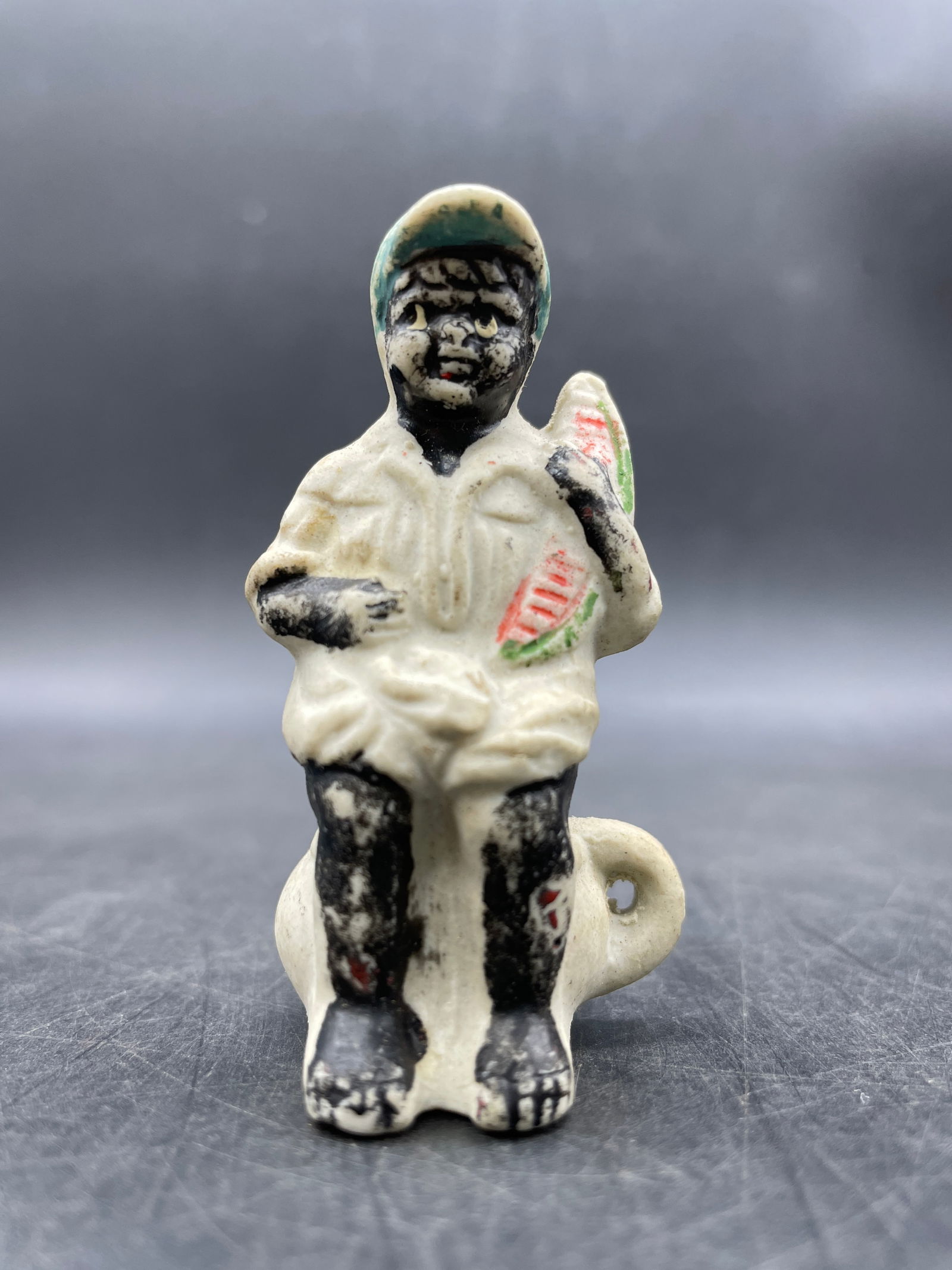 BLACK AMERICANA JAPAN BISQUE BLACK BOY ON CHAMBER POT W/ WATERMELON COIN IN BACK: Title: BLACK AMERICANA JAPAN BISQUE BLACK BOY ON CHAMBER POT W/ WATERMELON COIN IN BACK Date/Period: APPROX 1930-40'S Dimension: Approx 2.5" Material: bisque Additional Information: BLACK AMERICANA JA